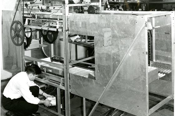 Historic prototype letter sorting machine for the US Post Office with an engineer loading mail