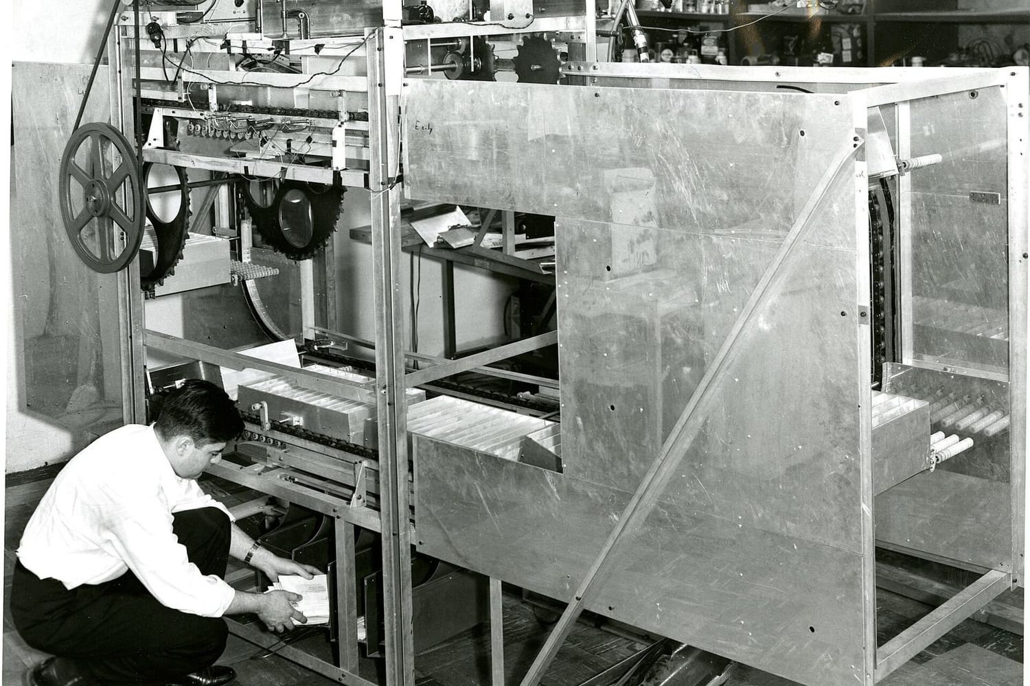 Historic prototype letter sorting machine for the US Post Office with an engineer loading mail
