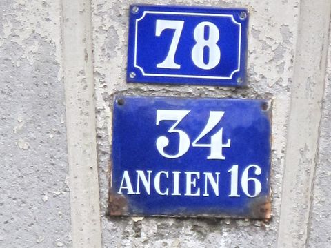 Blue enamel plates showing house numbers 78 and 34, old number 16, on one wall